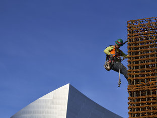 Man with Green Hardhat, Working from Staging at Construction Site