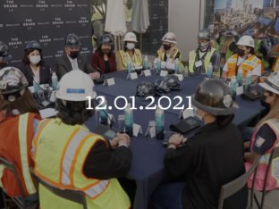 Large Table of Executives and Construction Workers with Hard Hats and Vests