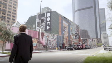 Man Walking Across a Crosswalk with the MOCA Exterior in the Background