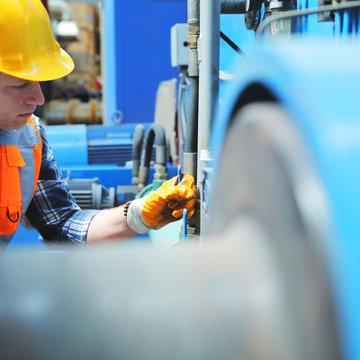 Man Wearing Yellow Hard Hat Fixing a Pipe
